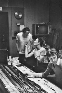The Clash in the recording studio: Mickey Foote engineer and The Clash ‘s live sound man at the mixing desk as Joe Strummer confers with Paul Simonon. CBS Studio 3, Whitfield Street, London. February 1977. © Caroline Coon